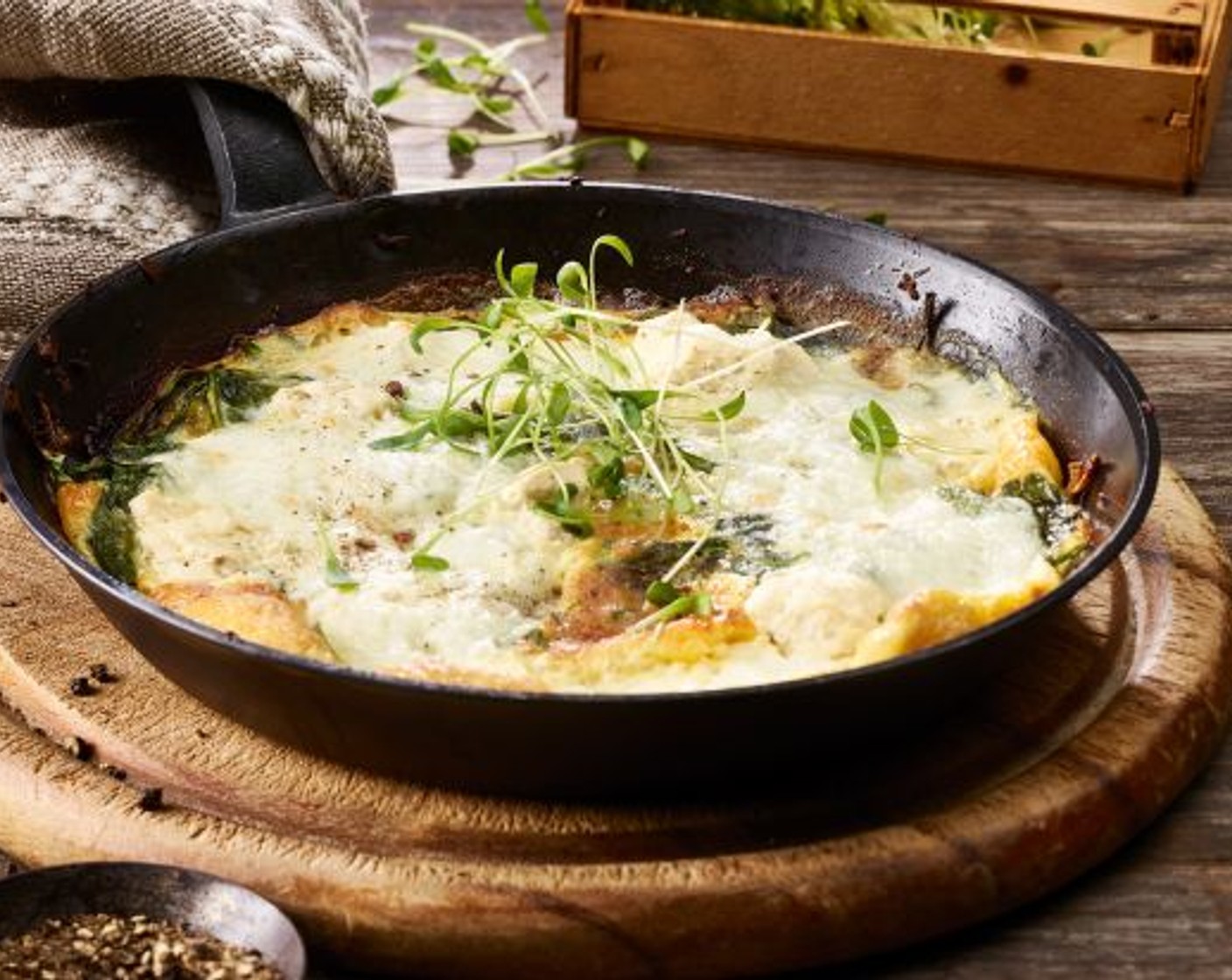 Schritt 6 Den Büffelmozzarella (1 Kugel) Scheiben schneiden. Die Omelette damit belegen. Die Pfanne sofort auf das Gitter auf der zweit-obersten Rille stellen und die Omelette so lange überbacken, bis der Käse geschmolzen ist und leicht braune Flecken hat. Herausnehmen, nach Belieben mit Gartenkresse (1 Handvoll), Portulak oder Rucola garnieren und sofort servieren.