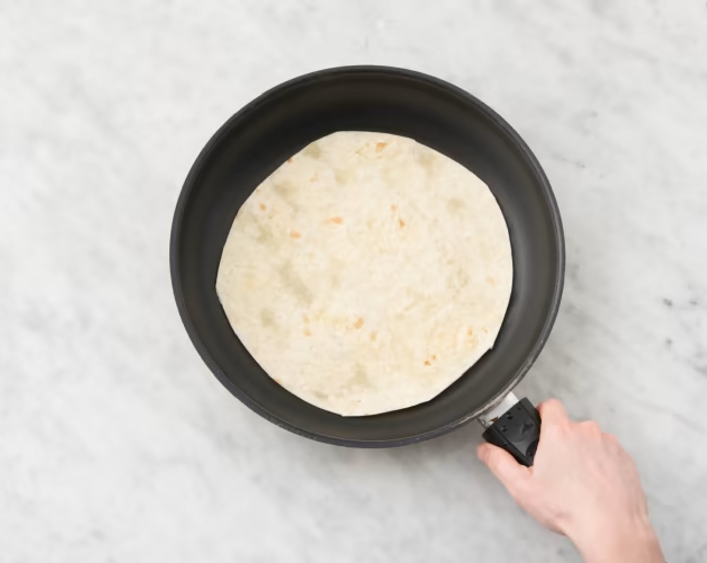 Schritt 5 Kurz vor dem Anrichten Avocados (2) halbieren, Kern entfernen, Fruchtfleisch herauslösen und in dünne Scheiben schneiden. Die grosse Bratpfanne mit Küchenpapier auswischen und Mais- Tortillas (8) nacheinander bei mittlerer Hitze 10–20 Sekunden je Seite erwärmen.