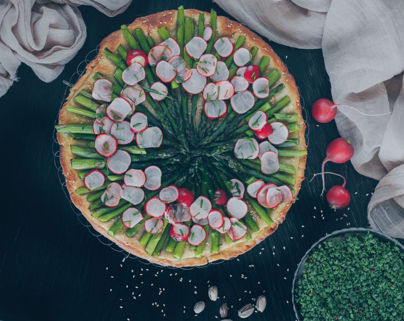 Schritt 10 Anschliessend die Tarte herausnehmen, Radieschen, Pistazien (1 Handvoll) und Sesam darauf verteilen. Zum Schluss die Cashew-Miso Crème darübergeben und servieren.