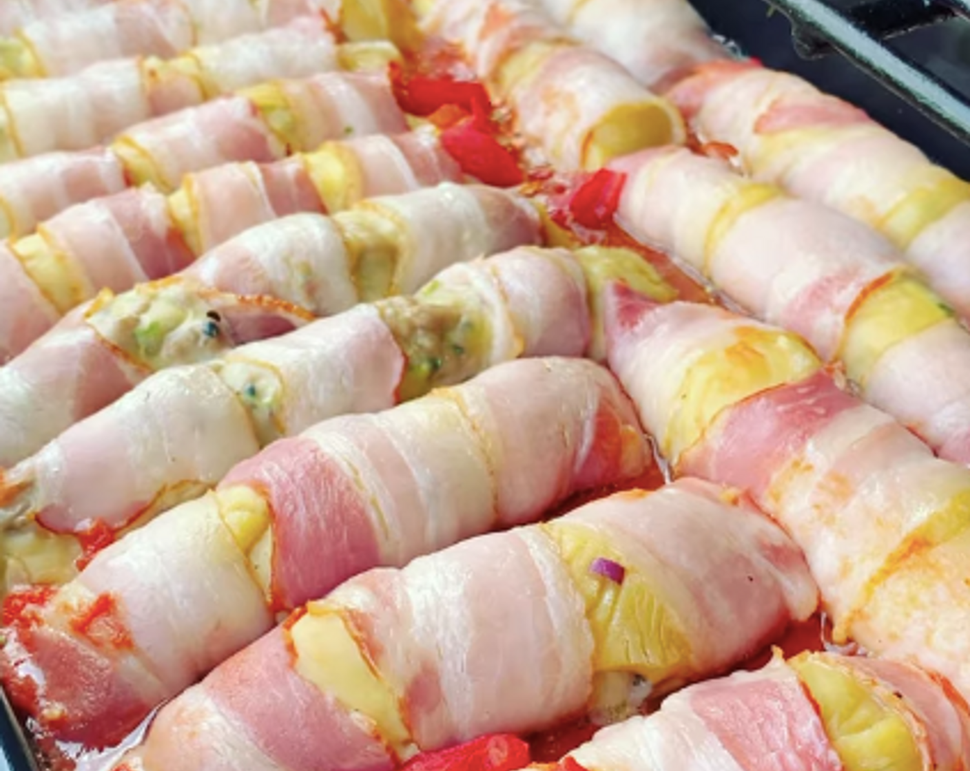 Schritt 9 Für die Sauce einen Topf auf mittlerer Hitze erwärmen, Pelati (1/2 Dose) und Gemüsebouillon (100 ml) hinzugeben und vermengen. Die Sauce gleichmässig über die Hackfleisch-Röllchen verteilen.