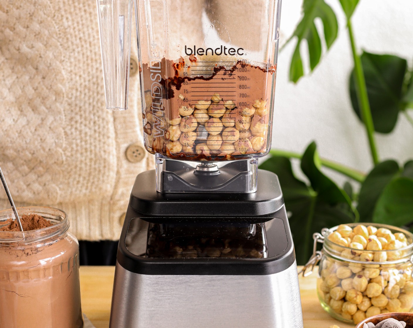 Schritt 1 Gib alle Haselnüsse (150 g), Schokolade (3 1/2 Esslöffel), Kakaopulver (30 g), Erythrit-Pulver (50 g) und Kokosöl (2 Esslöffel) in den Behälter des Blendtec 725 geben.