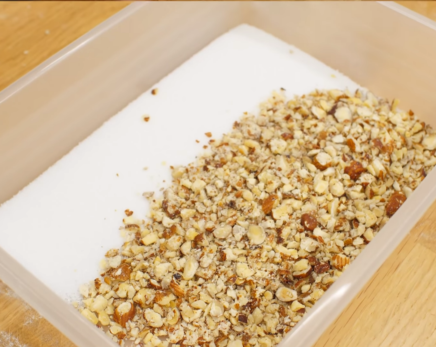 Schritt 14 Die Haselnüsse (1 Handvoll) auf ein Küchentuch geben, mit demselben Küchentuch zudecken und mit einem Rollholz kräftig darauf schlagen. Danach die gehackten Nüsse zum Zucker (wenig) geben (Verhältnis 1:1) und gut zusammen vermischen.