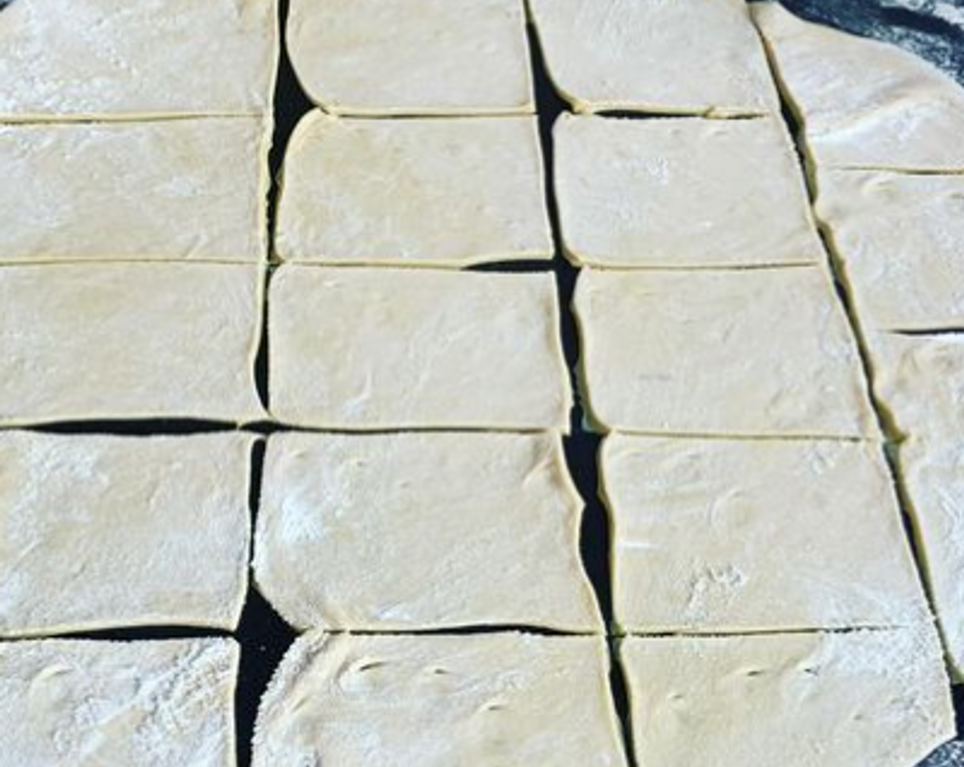 Schritt 4 Den Teig auf einer bemehlten Arbeitsfläche dünn ausrollen. Dann in 16 rechteckige Stücke schneiden.