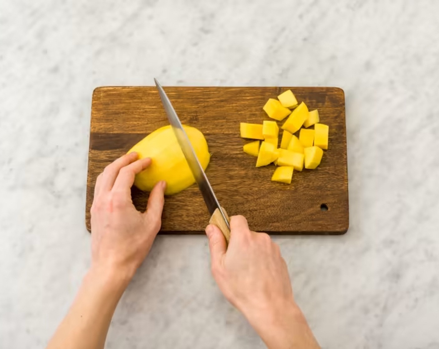 Schritt 3 Für die Mango-Salsa Mangos (2) schälen, Fruchtfleisch vom Kern schneiden, in ca. 0,5 cm grosse Würfel schneiden und in eine grosse Schüssel geben. Chilis (2) halbieren, Kerne entfernen und Chilihälften fein hacken. Korianderblätter (20 g) abzupfen und ebenfalls fein hacken. Gehackten Chili (Vorsicht: scharf!) und Korianderblätter zu den Mangowürfeln geben, mit Salz (wenig) und Pfeffer (wenig) abschmecken.