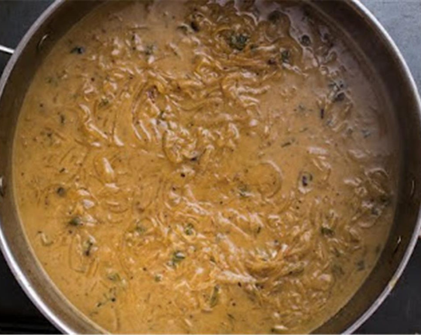 Schritt 14 Den Topf mit den Zwiebeln und der Brühe auf den Herd stellen und geben die restliche Brühe zusammen mit Apfelessig (3 Esslöffel), Rahm (2 Esslöffel), und Thymian (2 Teelöffel) hinzugeben. Mit Salz und Pfeffer würzen und für 10 Minuten köcheln lassen.