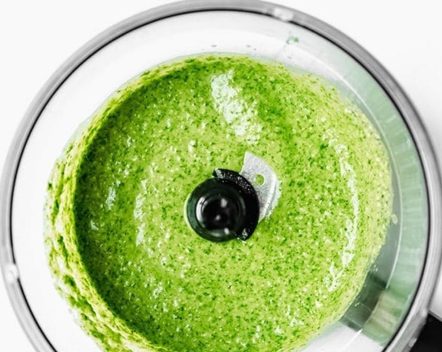 Schritt 1 Basilikumblätter (20 g), Pinienkerne (80 ml), Parmigiano-Reggiano (50 g), Knoblauch (3 Zehen), Salz (1/2 TL) und Pfeffer (1/2 TL) in eine Küchenmaschine geben und mixen, bis alles gleichmässig vermischt und fein gemahlen ist. Mit einem Löffel oder Spatel die Seiten abschaben, um sicherzustellen, dass alles gut vermischt ist.