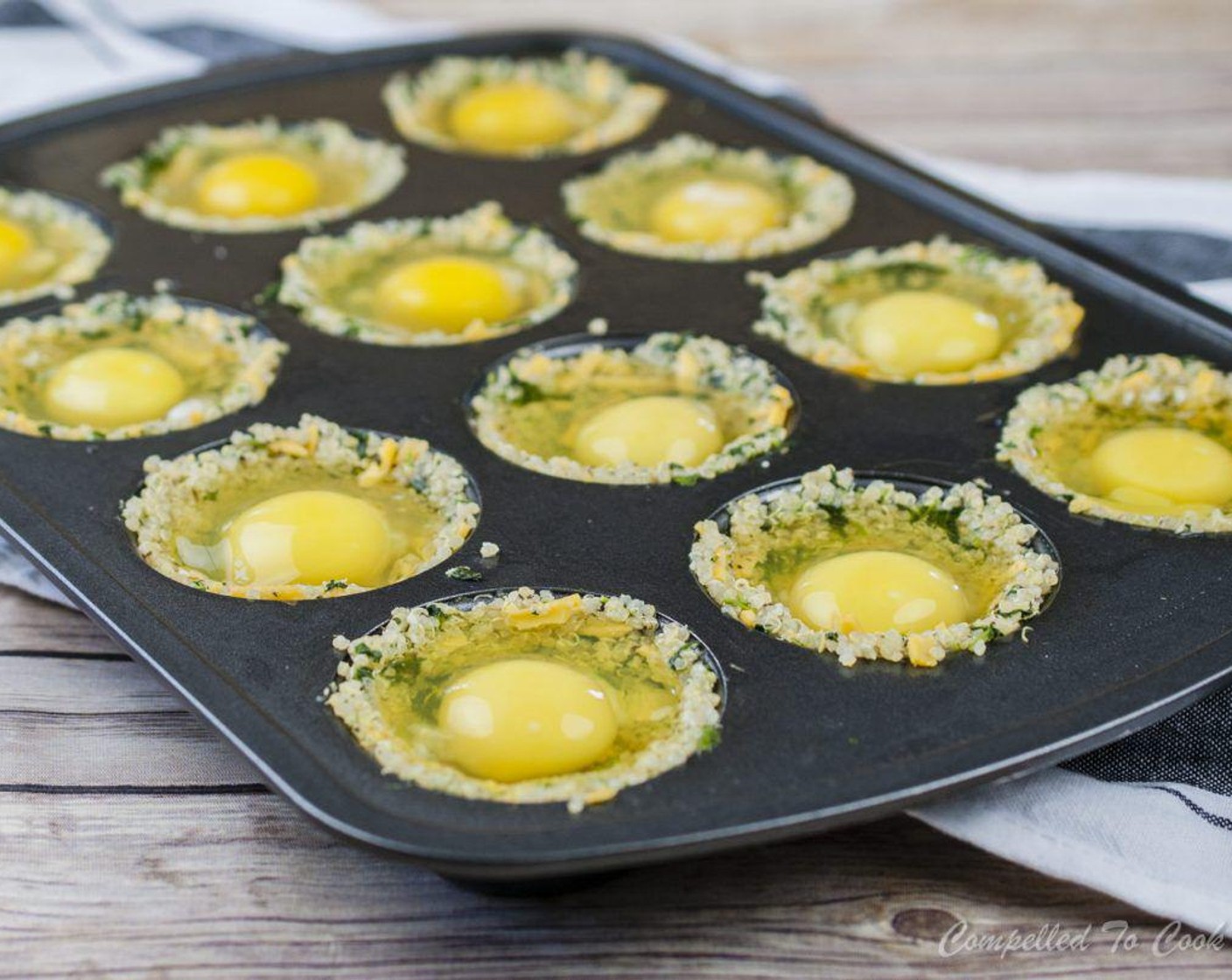 Schritt 5 Eier (12) in jede Mulde schlagen und mit Cheddar (60 g) bestreuen.