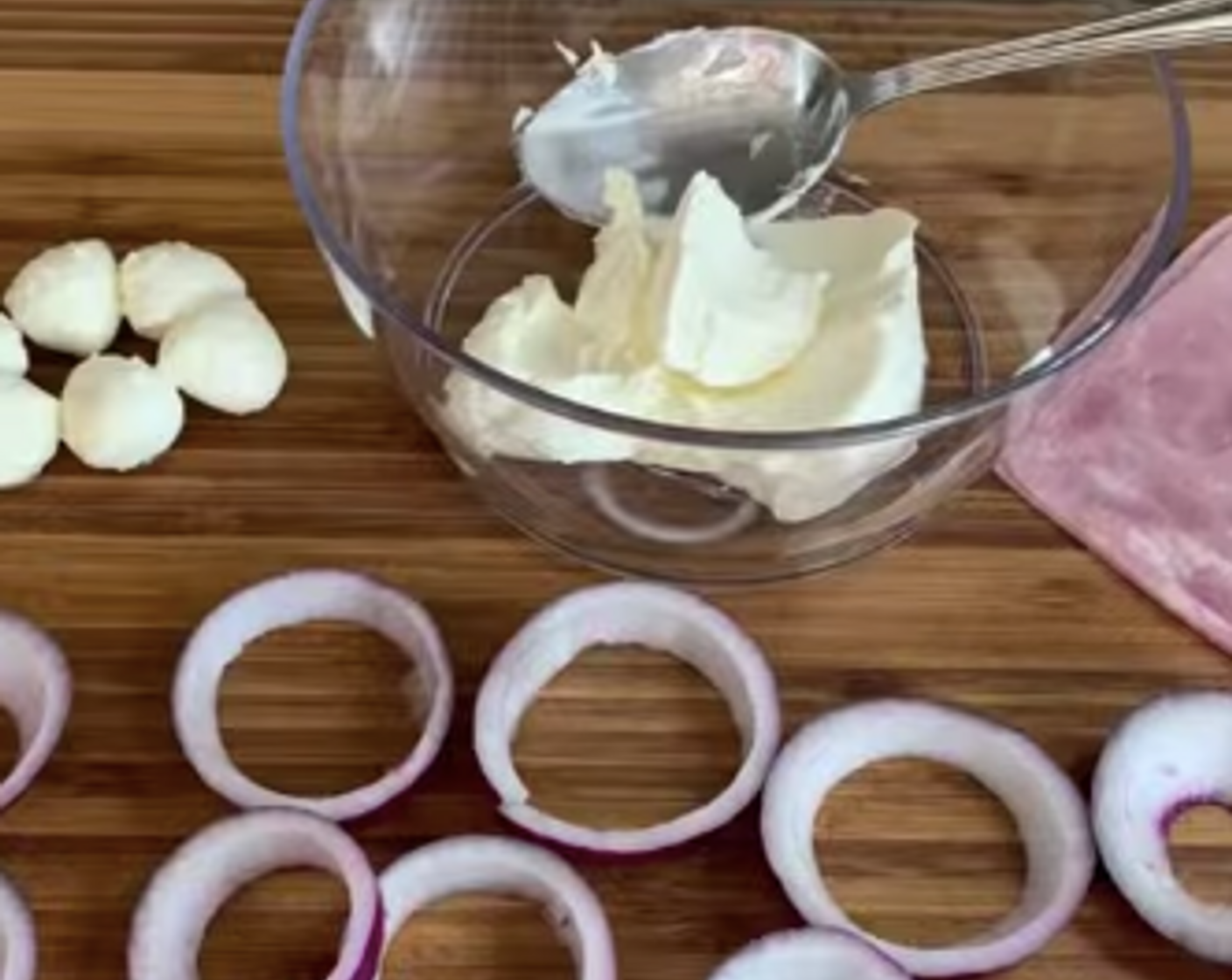 Schritt 1 Zwiebeln (2) schälen und in Ringe schneiden. Die Ringe voneinander lösen auf der Arbeitsfläche verteilen.