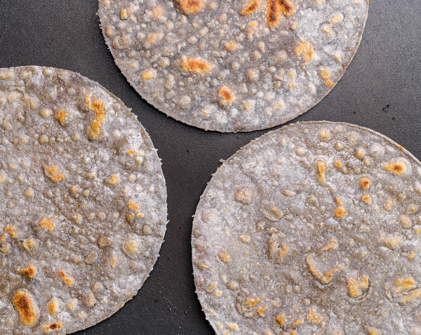 Schritt 5 Erhitze eine Pfanne und bestreiche sie mit Sonnenblumenöl (1 EL). Bestreiche die Tortillas (4) mit Öl (2 Esslöffel) und jeweils 2 Minuten auf jeder Seite anbraten.