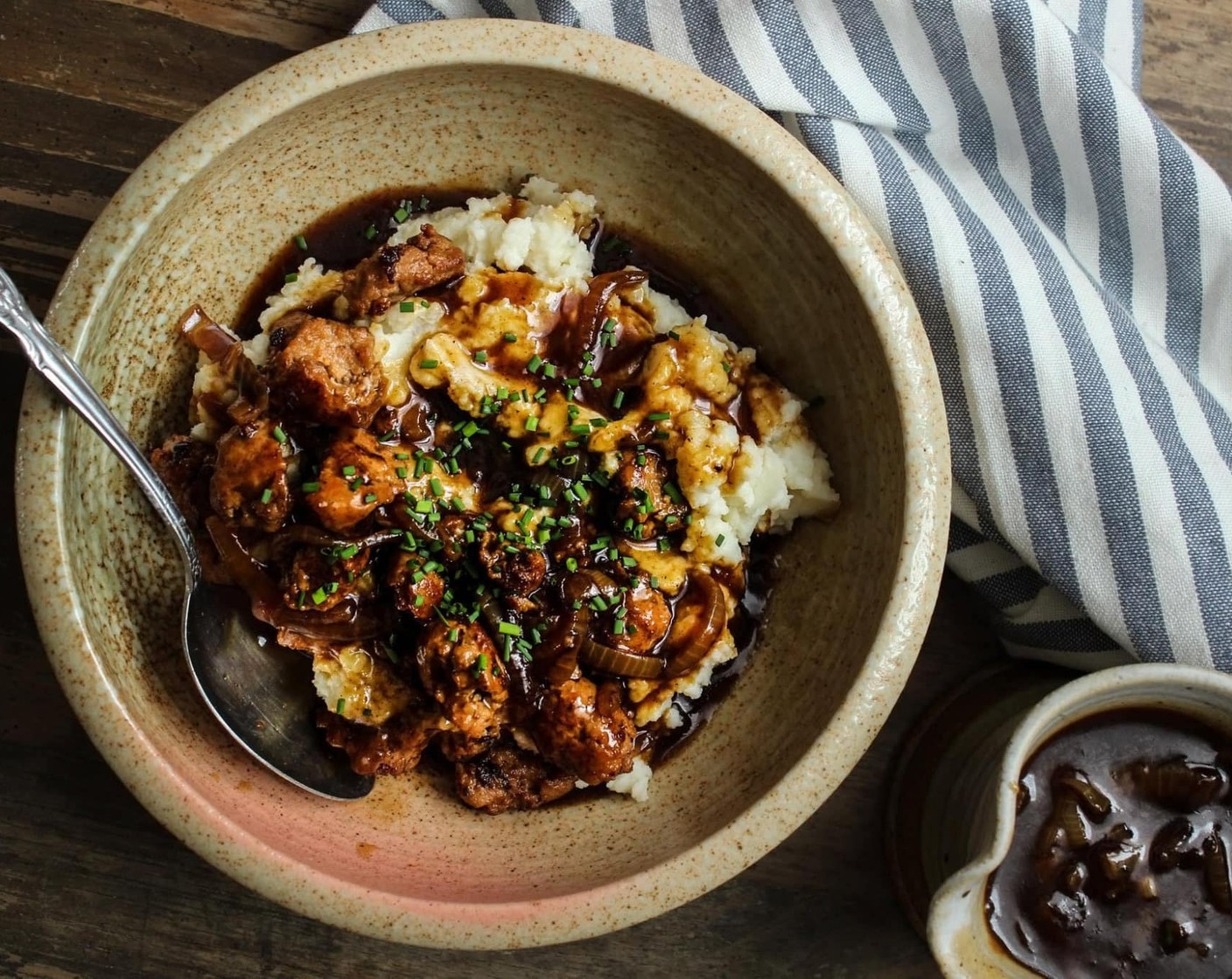 Schritt 21 In einer Servierschüssel erst das Kartoffelpüree und darauf die Wurst und die Sauce anrichten. Guten Appetit!