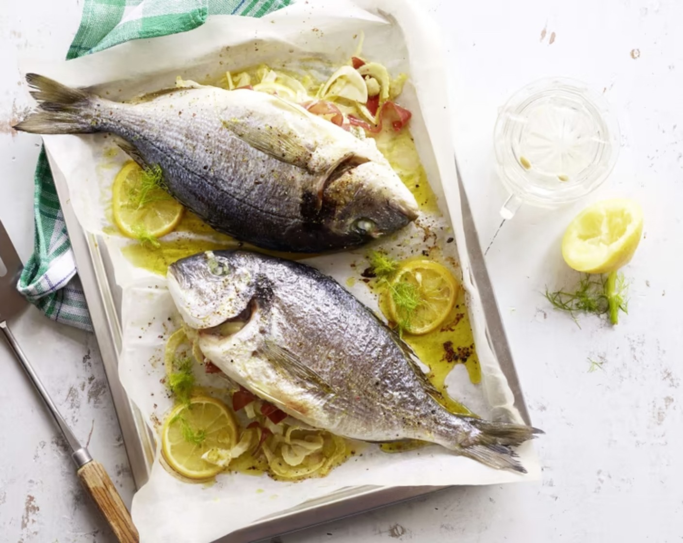 Schritt 4 Den Fisch das vorbereite Blech legen. In der Ofenmitte im vorgeheizten Ofen bei 200 °C Unter-/Oberhitze für ca. 30 Minuten garen. Mit Fenchelgrün servieren.