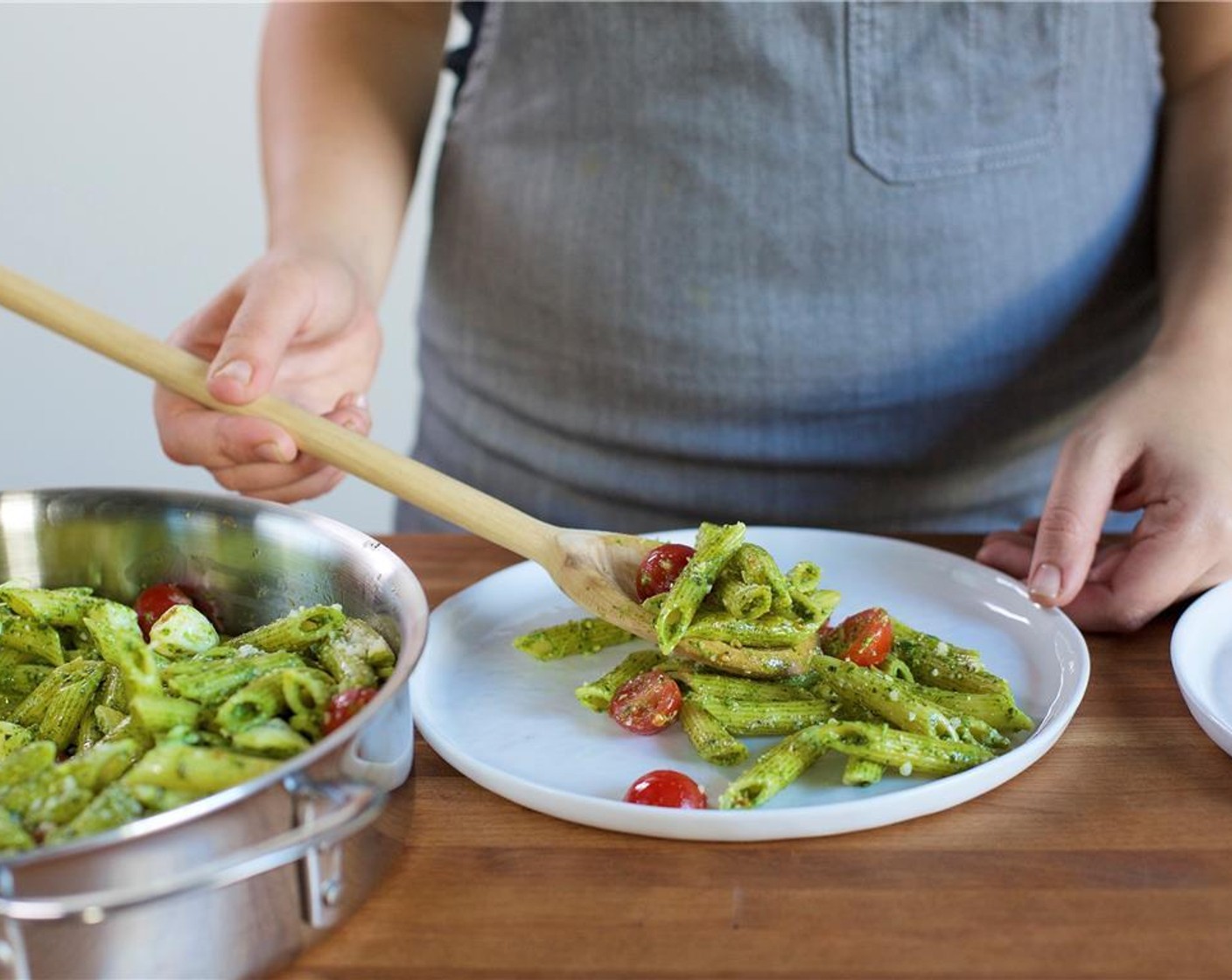 Schritt 8 Die Nudeln in der Mitte von zwei Tellern anordnen und gleichmässig mit Tomaten und Mozzarella-Käse belegen. Mit dem restlichen Parmesan (4 Esslöffel) bestreuen.