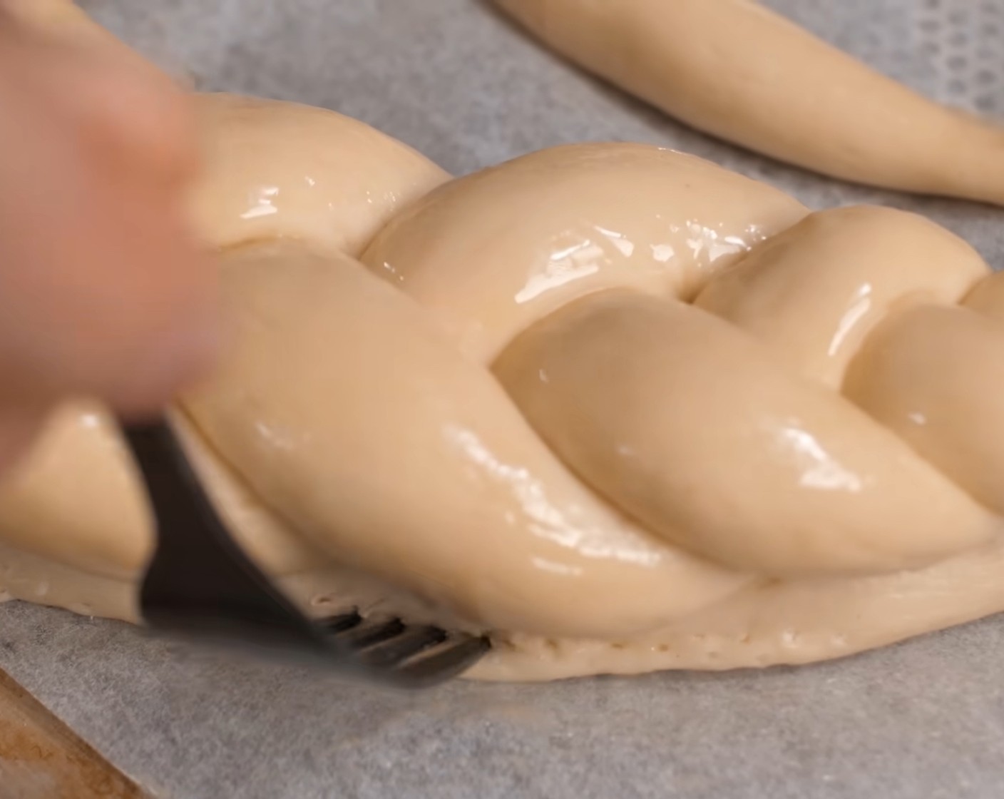 Schritt 23 Vor dem Backen die Brezel nochmals mit einem verquirlten Ei bestreichen und unterhalb des Zopfes mit einer Gabel leicht stupfen, d.h. Löcher einstechen.