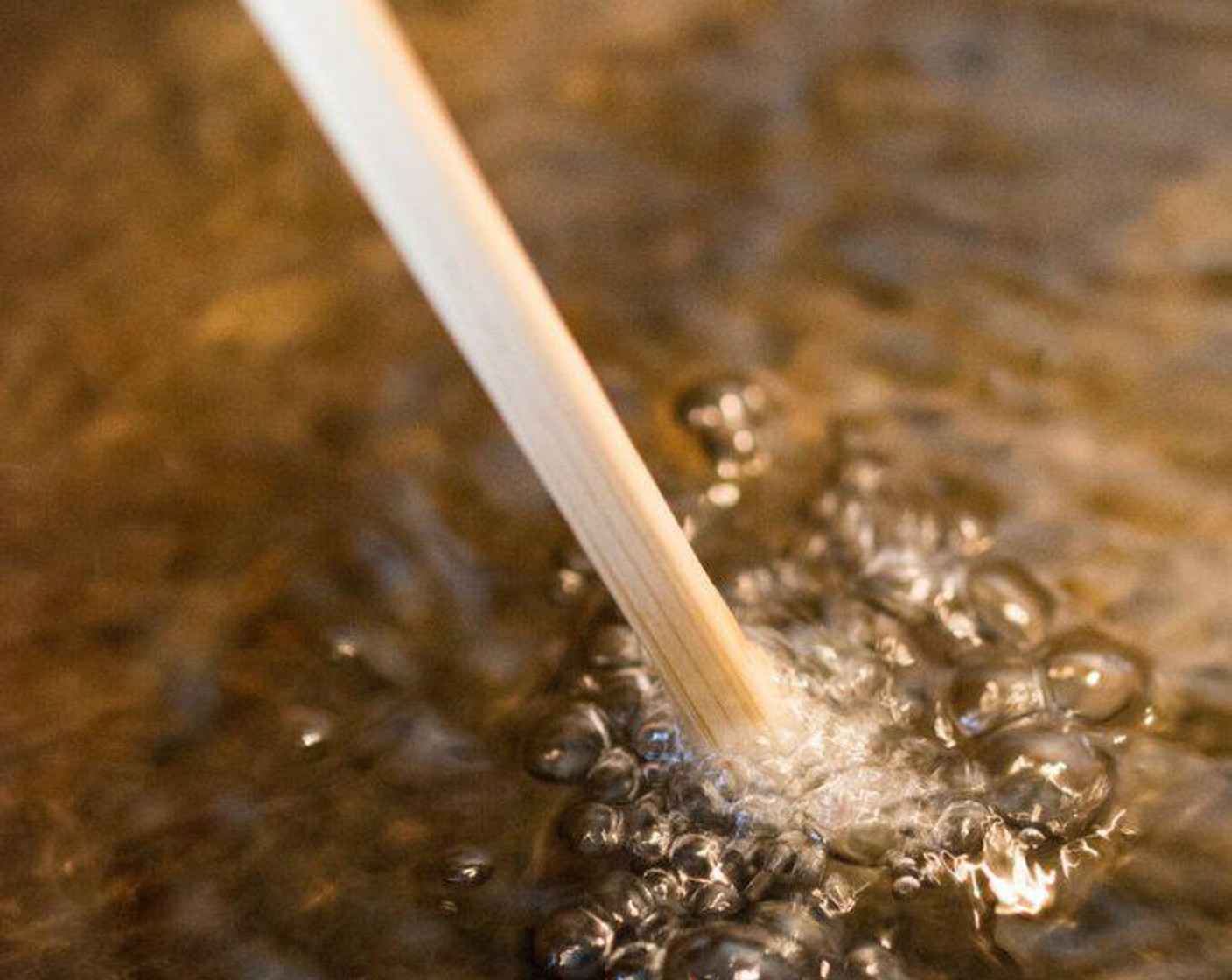 Schritt 2 Kochöl (wenig) im Wok oder einem grossen Topf erhitzen. Mit einem Holzstäbchen oder Holzlöffel prüfen, ob das Öl heiss genug ist.