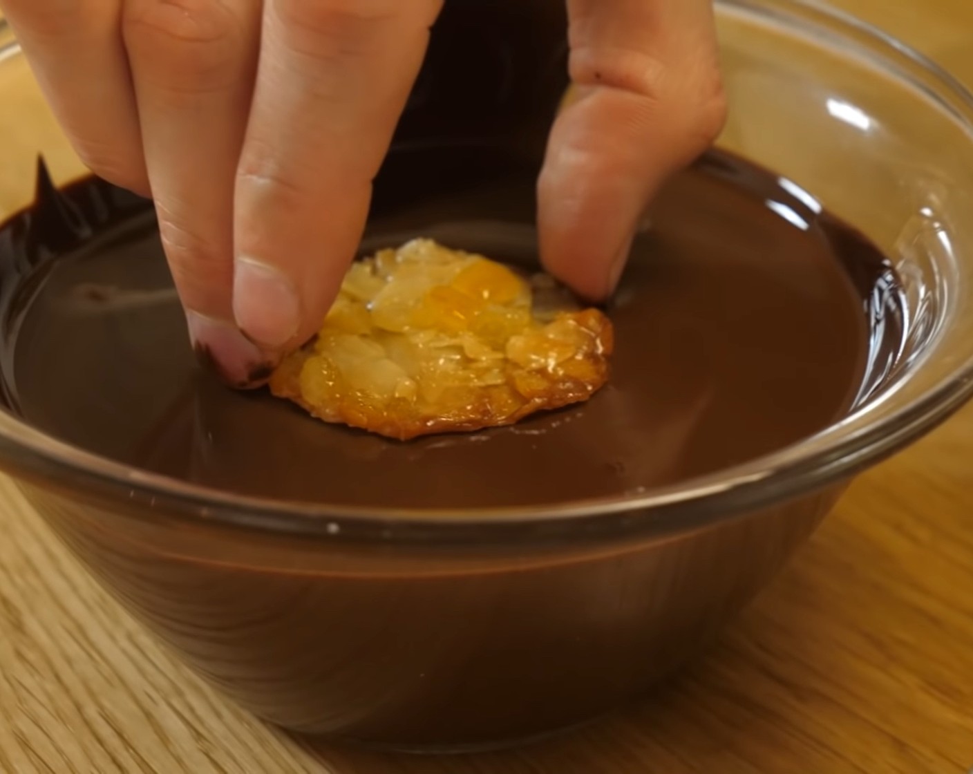 Schritt 12 Die gut ausgekühlten Florentiner mit dem Boden in die temperierte Kuvertüre tunken.