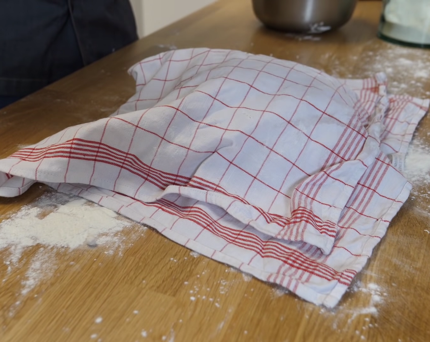 Schritt 7 Anschliessend den Teig auf etwas Mehl geben und auch die Oberfläche mit etwas Mehl stauben. Den Teig nochmals mit dem Küchentuch zudecken und für weitere 2 Stunden ruhen lassen.