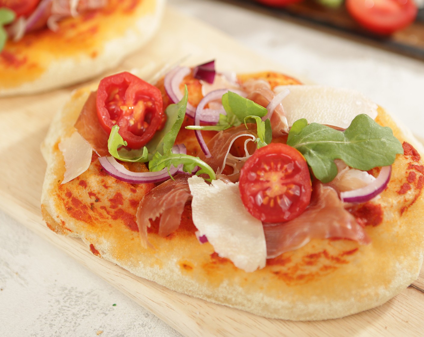 Schritt 15 Nach dem zweiten Mal Backen die Pinsen mit den Parmesan (wenig), Zwiebeln (wenig), Prosciutto Crudo (wenig), Rucola (wenig) und Cherrytomaten (wenig) belegen und geniessen.