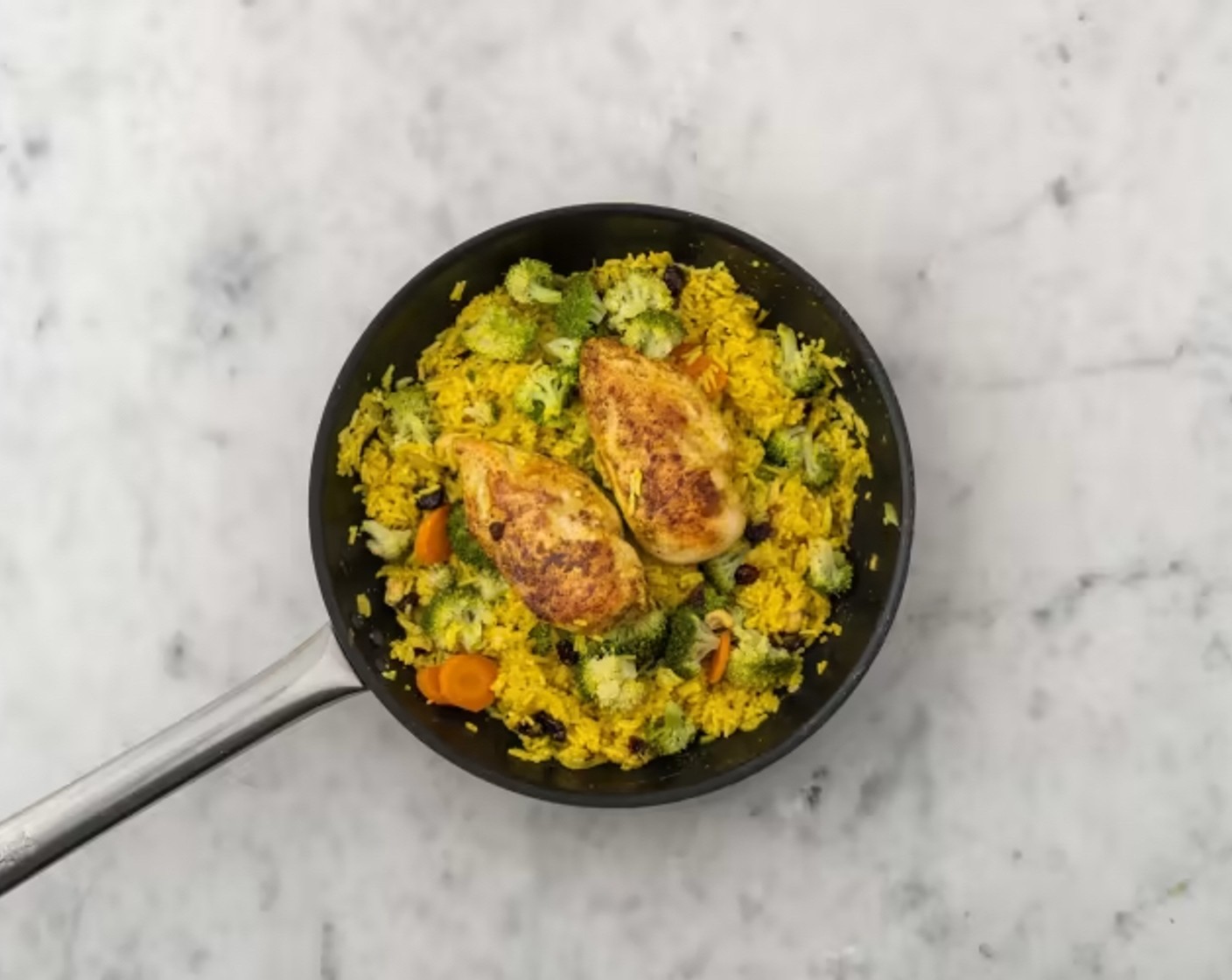 Schritt 5 Bratpfanneninhalt, mit heissem Wasser, Geflügelbouillon (8 g) und Curry, gemahlen (1/2 TL) ablöschen. Korma-Paste (100 g) hineinrühren, Cranberries dazugeben, einmal aufkochen lassen, Pouletfilets auf den Reis legen und dann abgedeckt bei mittlerer Hitze 12 Minuten köcheln lassen, bis der Reis gar ist.