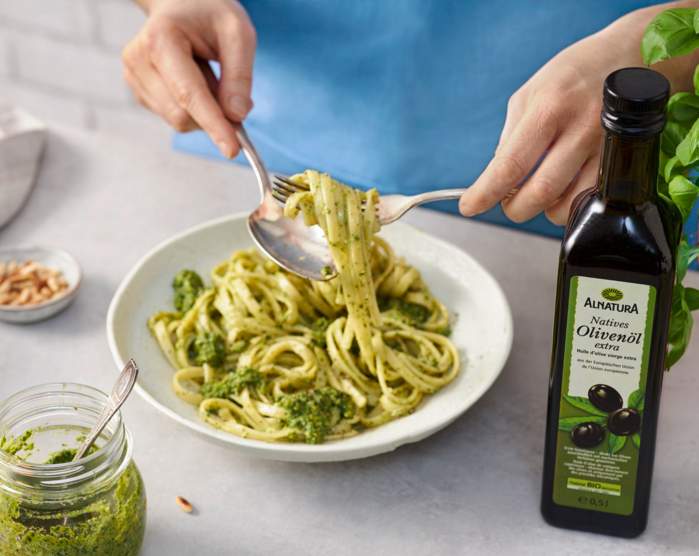 Schritt 3 Pinienkerne, Basilikumblätter, Knoblauch mit Olivenöl (100 ml), Salz (1/2 TL) und Pfeffer (1/4 TL) in ein hohes Gefäss geben und mit einem Stabmixer zu einer geschmeidigen Paste verarbeiten. Den geriebenen Parmesan unterheben. Falls das Pesto zu dick ist, noch etwas Olivenöl hinzufügen.