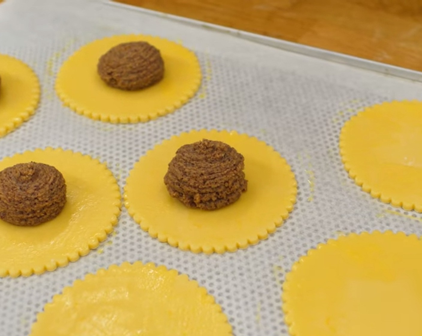 Schritt 10 Die vorbereitete Nussfüllung in einen Spritzbeutel geben und in die Mitte der Teigrondelle kleine Kugeln spritzen.
