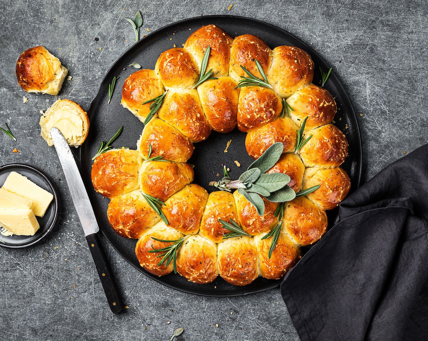 Schritt 7 Den Brotkranz im heissen Ofen auf der mittleren Schiene 15 bis 20 Minuten goldbraun backen. Auf einem Gitter auskühlen lassen. Zum Servieren mit Rosmarin (1 Handvoll) und Salbei (1 Handvoll) dekorieren.