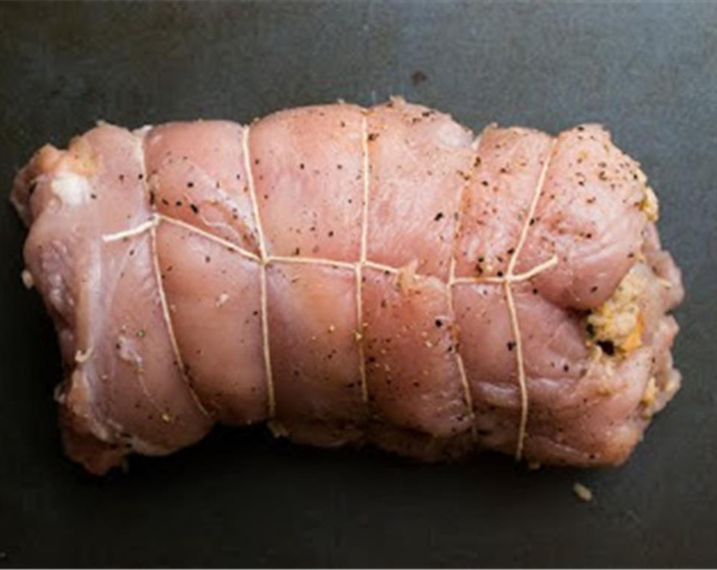 Schritt 9 Am schmalsten Ende anfangen und die Roulade wie eine Biskuitrolle aufrollen. Alle herausfallenden Füllungsstücke wieder in die Rolle hineindrücken und die Rolle mit Spiessen oder Küchengarn befestigen.