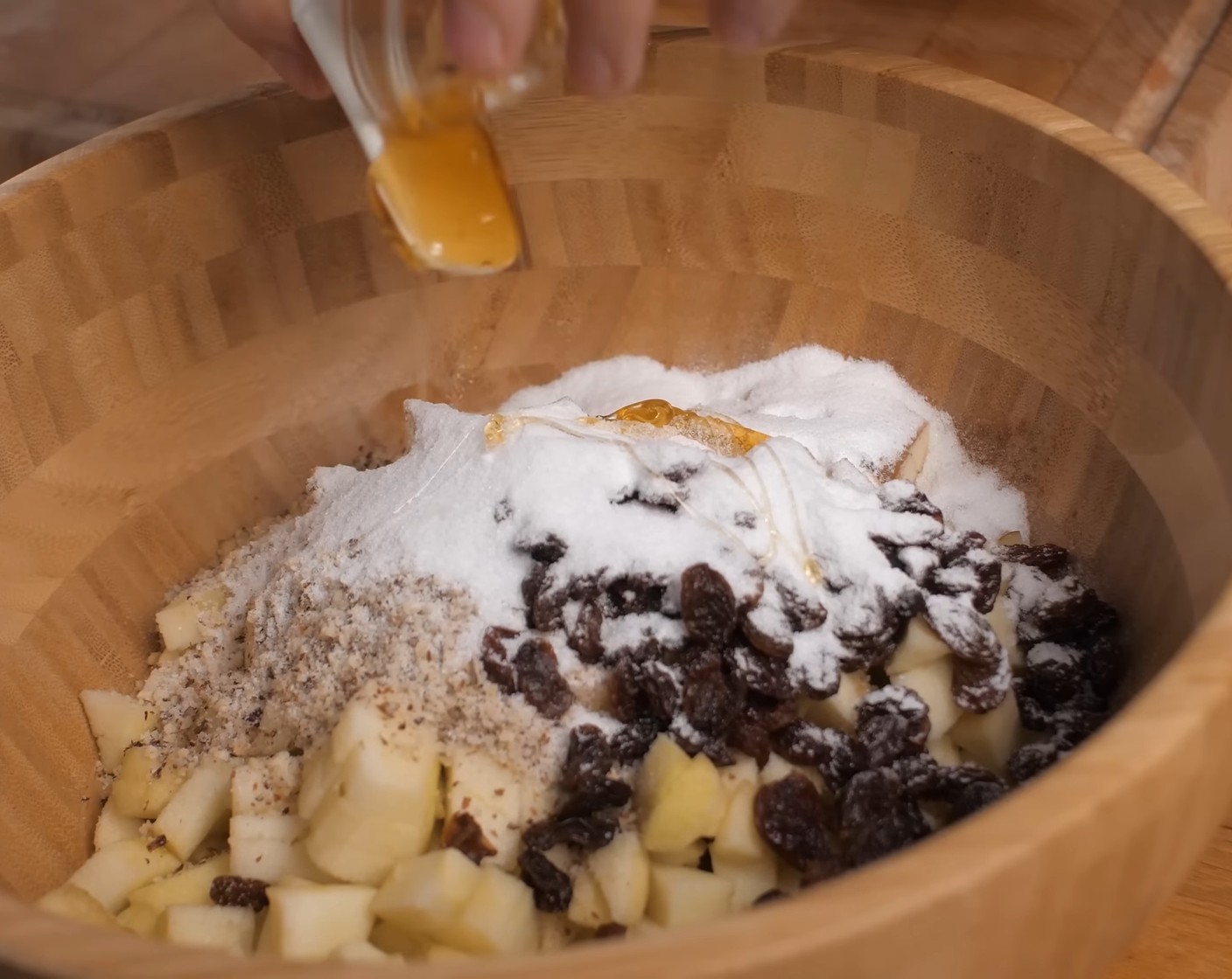 Schritt 8 Anschliessend Zimt (1 TL), Haselnüsse (50 g), Rosinen (50 g), Zucker (70 g) und Honig (3 Teelöffel) zu den Äpfeln geben und alles gut vermengen.