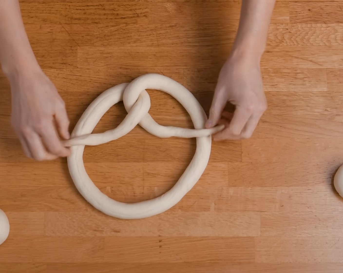 Schritt 13 Anschliessend aus diesem Strang eine Brezel formen und auf ein mit Backpapier belegtes Blech legen.