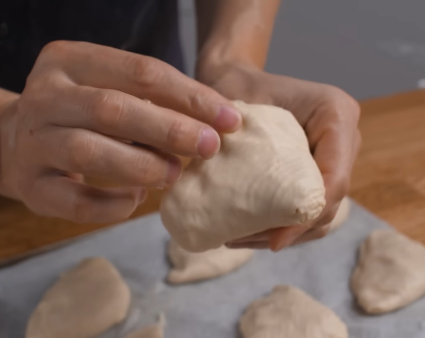 Schritt 16 Eine Teigscheibe auf beide Daumen legen und mit den Fingern von der Mitte her rundum nach aussen ziehen, dass ein Art Hut entsteht. Diesen «Hut» mit etwas Creme füllen, die Öffnung gut zusammendrücken und den Teigling auf ein mit Backpapier belegtes Blech legen. Die restlichen Teigscheiben nach demselben Verfahren füllen und schliessen.