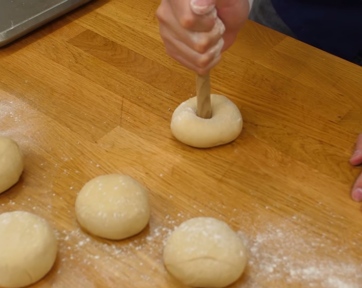Schritt 5 Als nächstes die Kugeln leicht bemehlen und in die Mitte jeder Kugel mit einem Kellenstiel ein Loch durchstossen.