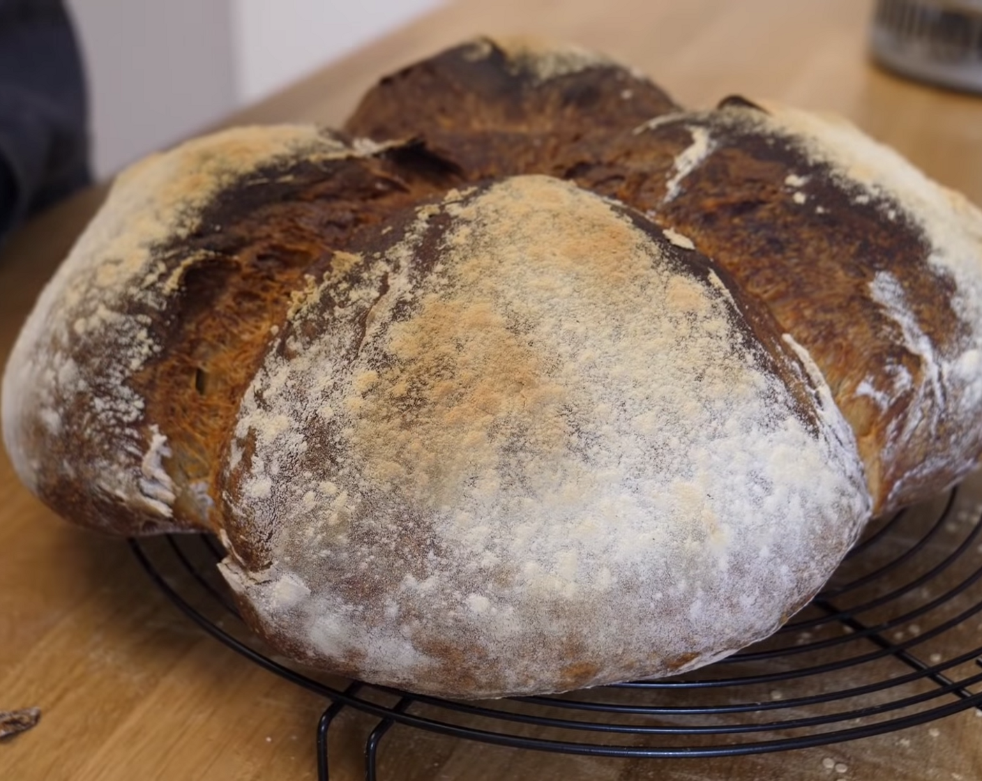 Schritt 10 Das Blech mit dem Teigling auf die mittlere Schiene im auf 230 Grad Ober/Unterhitze vorgeheizten Backofen schieben und den Ofen grosszügig mit Wasser einsprühen. So kannst du den gewünschten Dampf erzeugen. Sofort die Ofentür schliessen und das Brot für zirka 30 Minuten backen. Danach die Temperatur auf 210 Grad reduzieren und das Brot weitere 30 Minuten fertig backen. Direkt nach dem Backen das Brot auf einem Gitter auskühlen lassen.