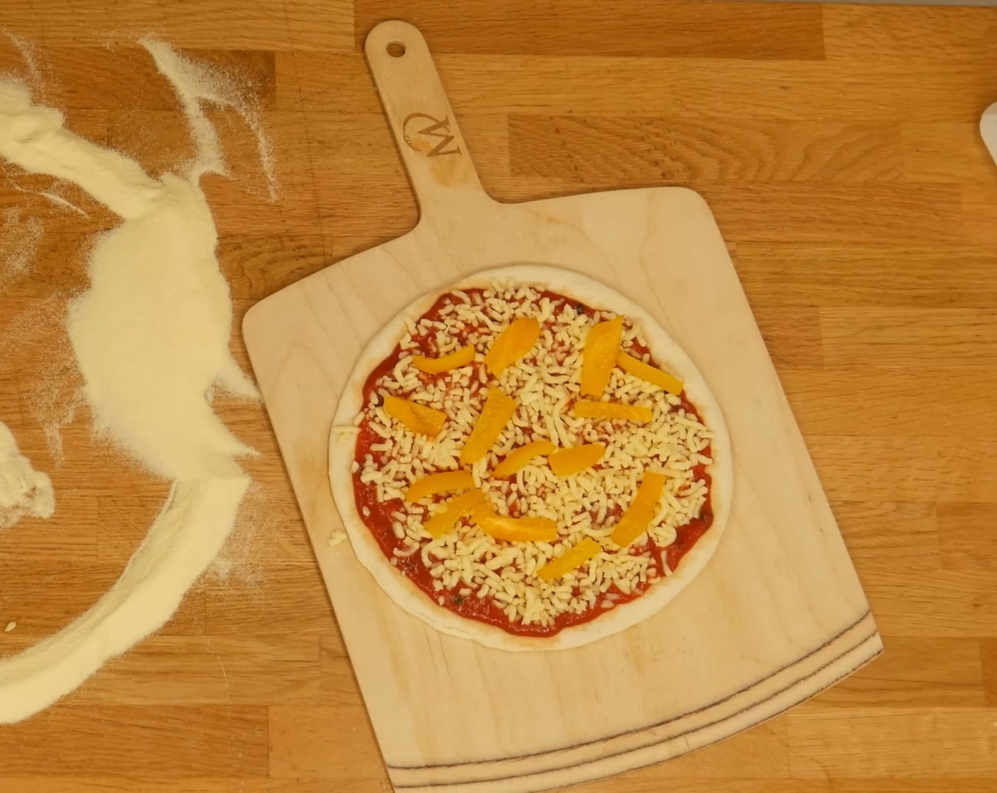 Schritt 10 Anschliessend die geformten Pizzaböden entweder auf ein Backpapier oder auf eine Pizzaschaufel legen, mit Tomatensauce, etwas Mozzarella (wenig) darauf streuen und mit weiteren Zutaten deiner Wahl belegen.