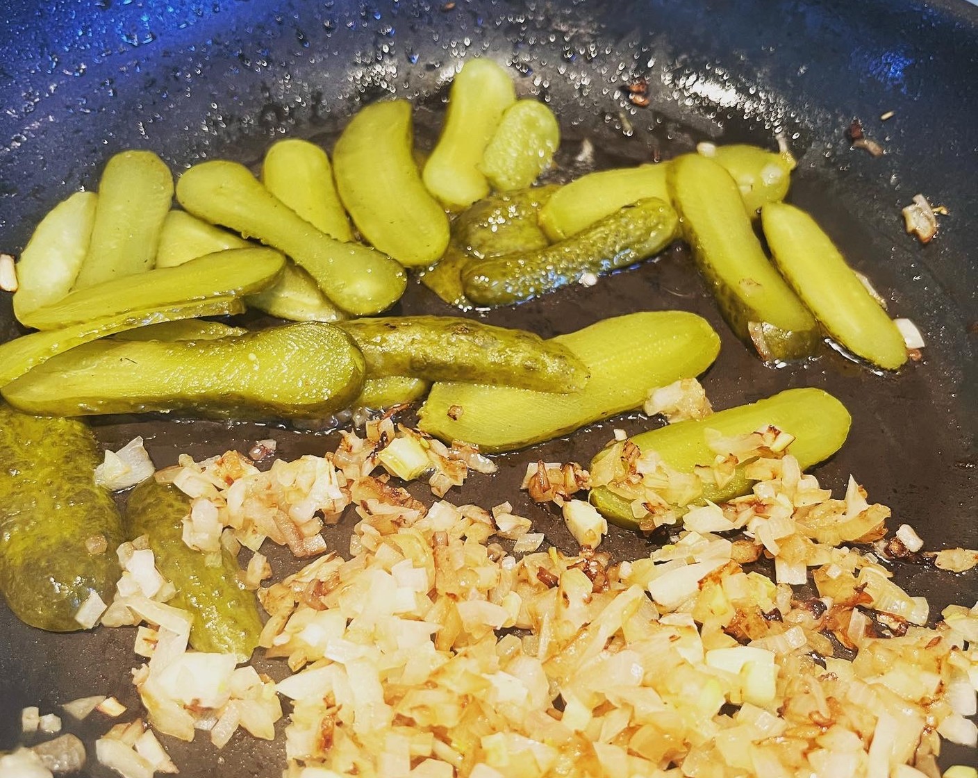 Schritt 4 In der gleichen Pfanne Essiggurke (1) und Zwiebel (1) glasig dünsten und ebenfalls beiseitestellen.