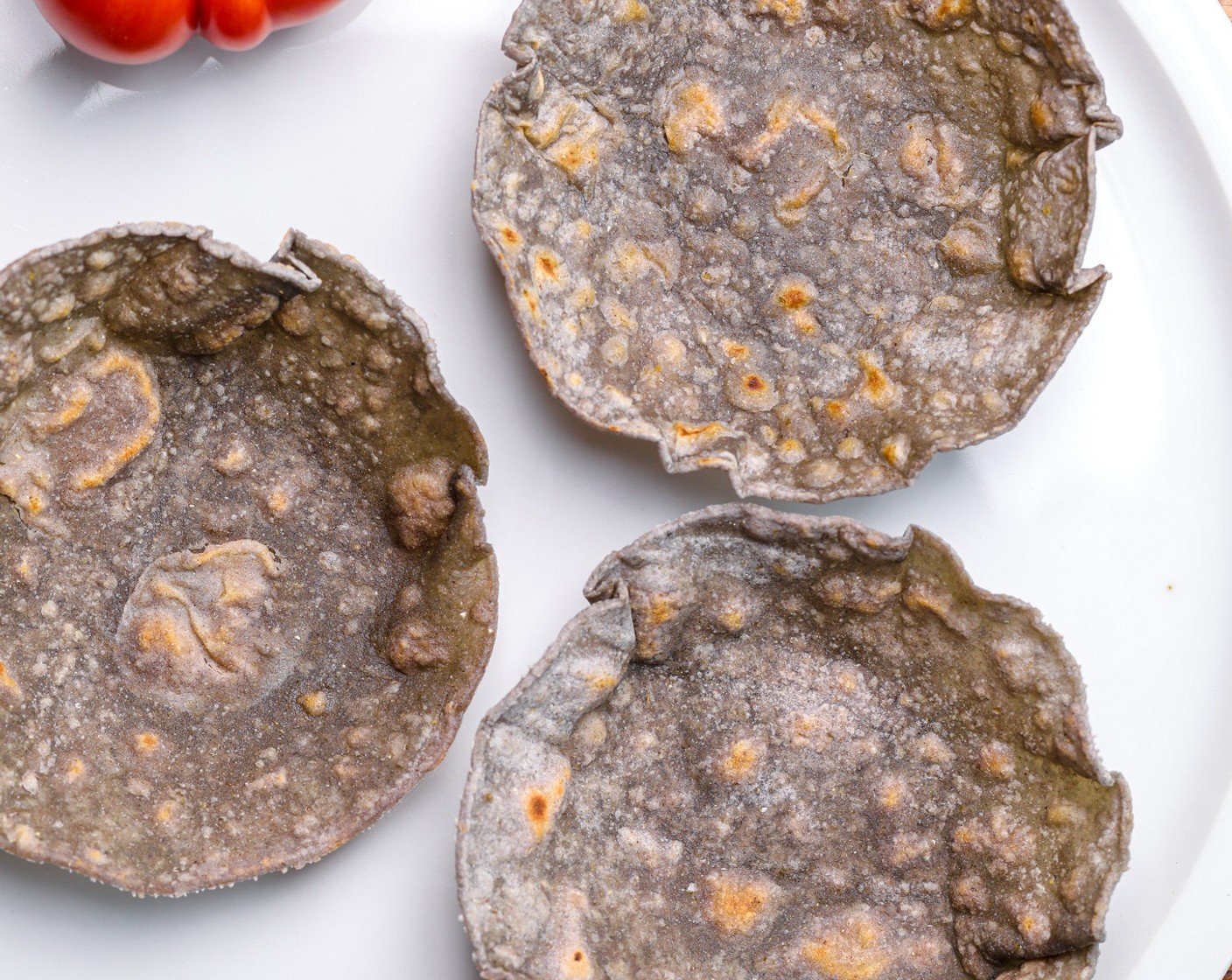 Schritt 6 Nimm jetzt eine saubere Schüssel, die etwa die gleiche Grösse wie die Tortillas hat, und eine etwas kleinere Schüssel, die in die grosse Schüssel passt. Drücke jede Tortilla zwischen die beiden Schüsseln und lass sie 2-3 Minuten ruhen, damit sie die Form annimmt. Wiederhole dies für jede gekochte Tortilla. Alternativ kannst du auch Muffin- oder Mini-Pie-Förmchen verwenden, um die Tortillas zu formen.