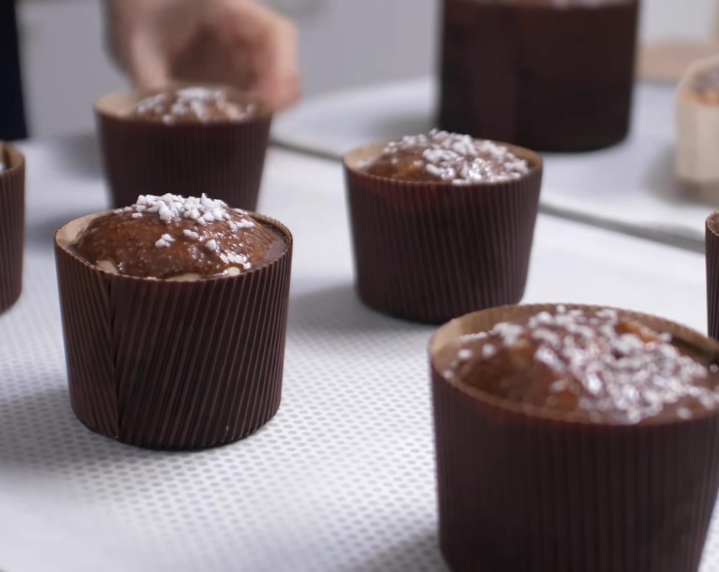 Schritt 14 Die Glasur in einen Spritzbeutel geben und damit dünn auf die Panettoni auftragen. Zum Schluss die Panettoni mit Hagelzucker (wenig) bestreuen.