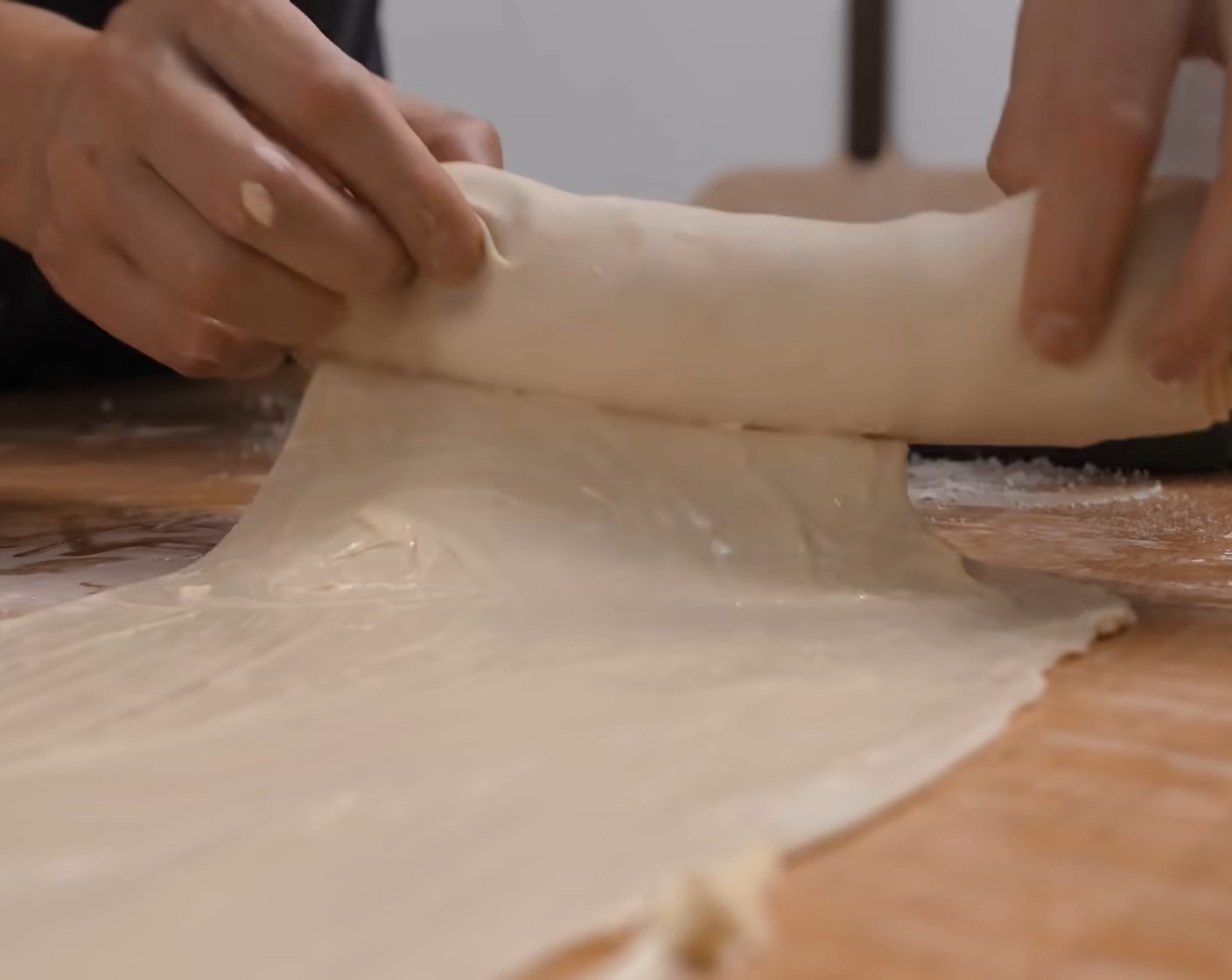 Schritt 11 Die Teigrolle an den zweiten Teigstreifen setzen und diesen wie beschrieben weiter einrollen.