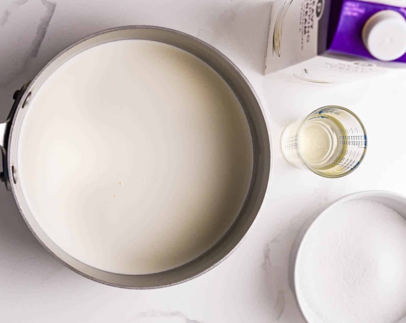 Schritt 7 Die restliche Milch (640 ml) zusammen mit Vollrahm (360 ml), Zucker (135 g) und Mais-Sirup (4 Esslöffel) in einen 4-Liter-Topf geben und bei mittlerer Hitze verrühren. Unter ständigem Rühren die Milchmischung zum Kochen bringen und für 4 Minuten kochen und rühren. Topf vom Herd nehmen.