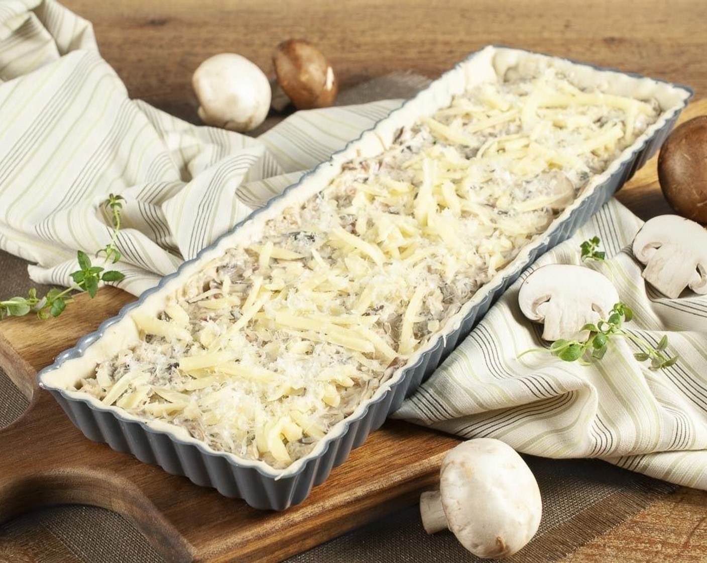 Schritt 8 Die Füllung gleichmässig auf dem Teig verteilen und mit dem restlichen Gruyère (4 Esslöffel) bestreuen. Etwa 25 Minuten im Ofen bei 210 °C backen, bis der Teig goldgelb ist.