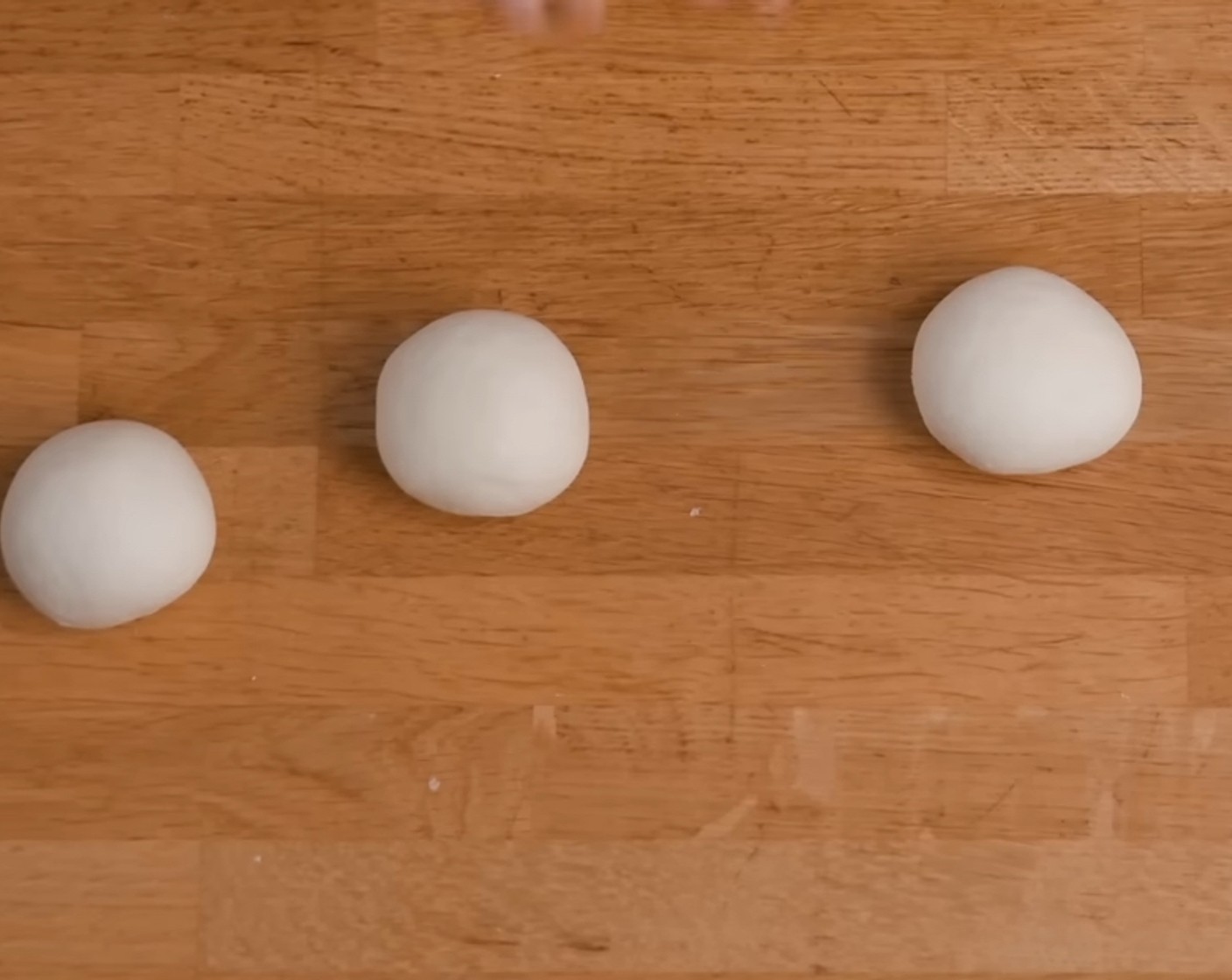 Schritt 10 Alle vier Teigstücks 2-3x über die Arbeitsfläche schleifen, um eine glatte Oberfläche zu bekommen und dann die Teiglinge rund formen.