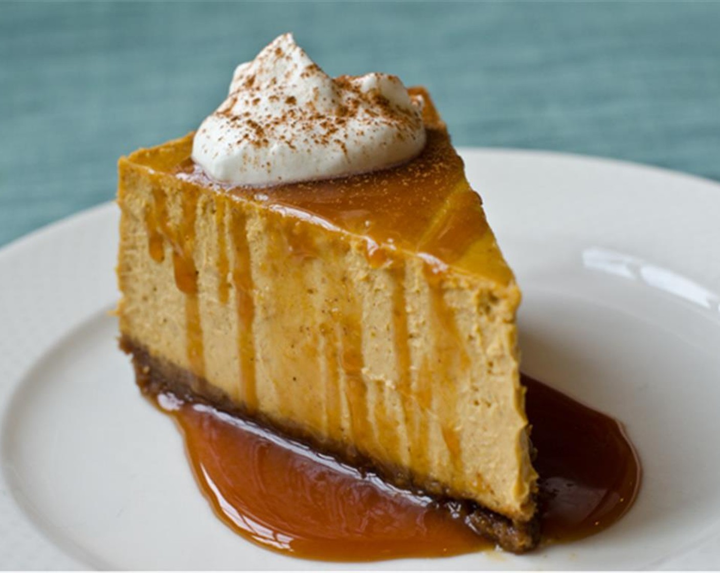 Schritt 17 Anschliessend den Käsekuchen in Stücke schneiden. Die Karamellsauce in der Mikrowelle erwärmen. Die Karamellsauce über jedes Stück Käsekuchen träufeln und nach Belieben mit einem Klecks gesüsster Schlagsahne belegen.