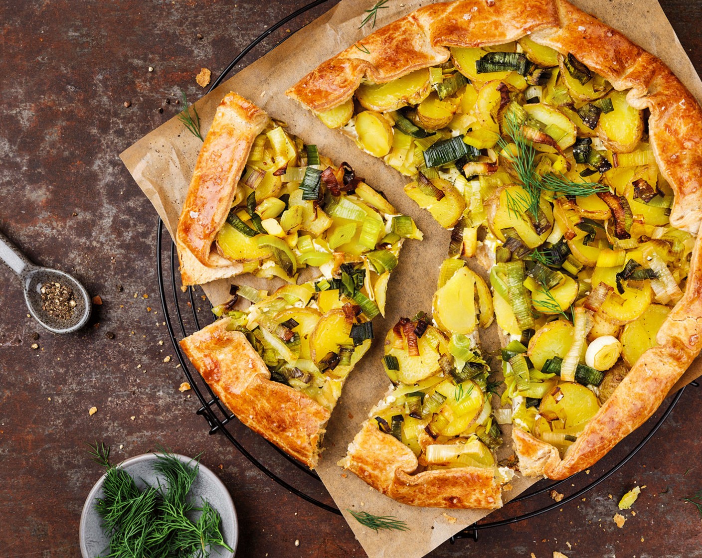 Schritt 6 Den Teigrand rundherum nach innen falten und mit Ei (1) bepinseln. Die Galette im vorgeheizten Ofen bei 180 °C Umluft für ungefähr 30 Minuten backen. Vor dem Servieren mit Dill (1 TL) bestreuen.