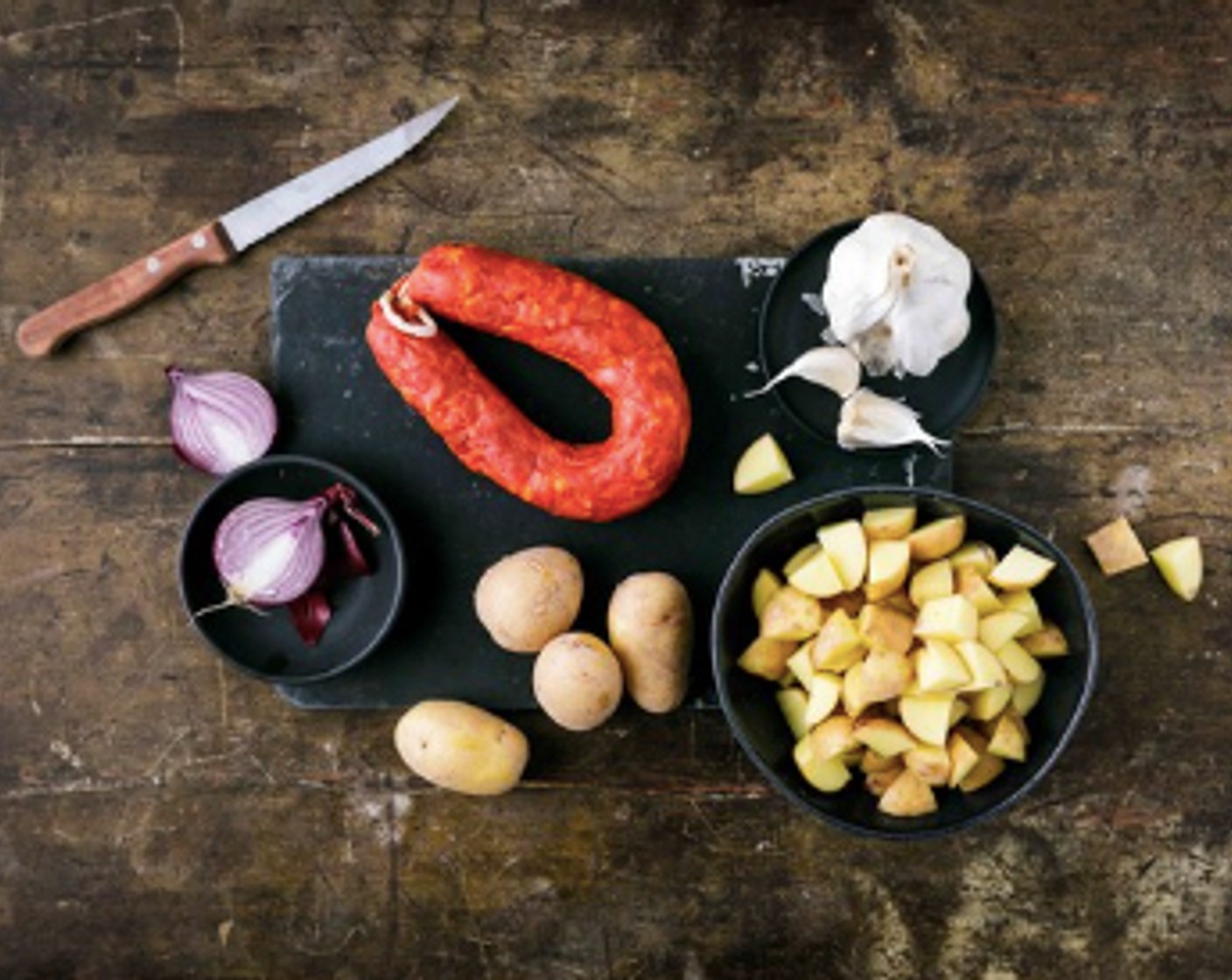 Schritt 1 Den Knoblauch (1 Zehe) sowie die Zwiebel (1) fein hacken. Die Kartoffeln (600 g) in ca. 1 cm dicke Würfel schneiden. Die Chorizo (200 g) in 1 cm dicke Scheiben schneiden. Das Öl (1 EL) in einer beschichteten Bratpfanne erhitzen. Die Chorizo Scheiben im heissen Öl 3 bis 4 Minuten anbraten. Aus der Pfanne nehmen und für später zu Seite stellen.