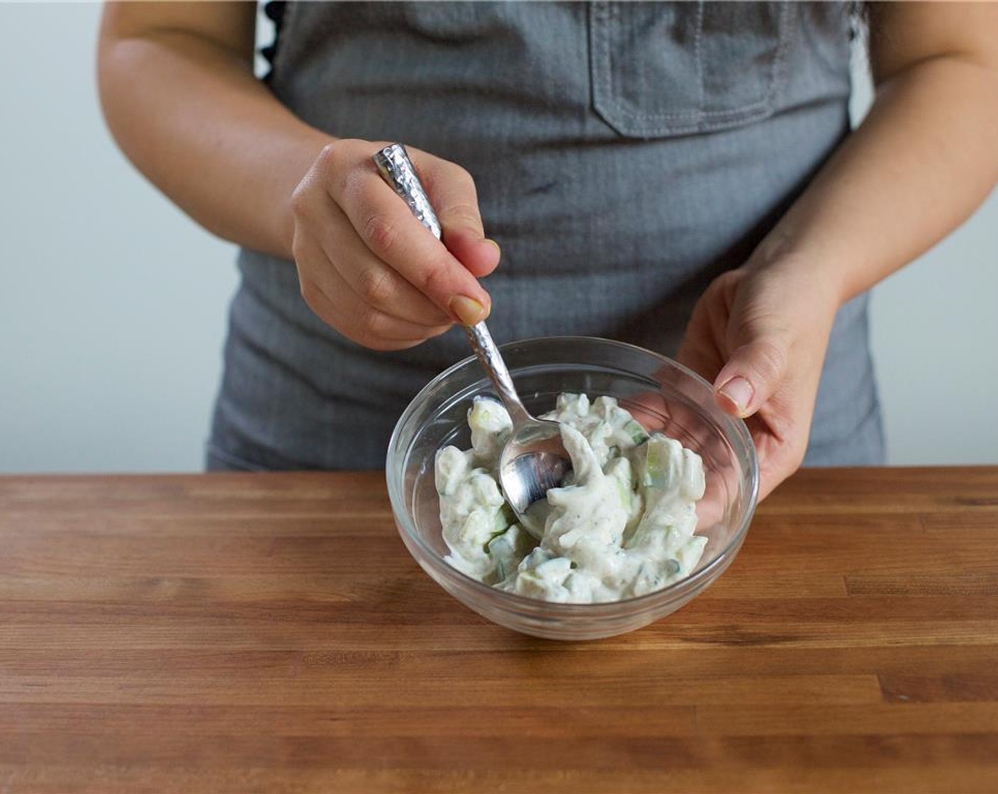 Schritt 2 Um die Raita zuzubereiten, in einer kleinen Schüssel den Saft der restlichen Limette auspressen, 1/4 Teelöffel Koriander (1/4 TL), 1/4 Teelöffel Kreuzkümmel (1/4 TL), den restlichen Joghurt,  Salz (1/4 TL) und Pfeffer (1/4 TL) hinzugeben. Gut vermischen.