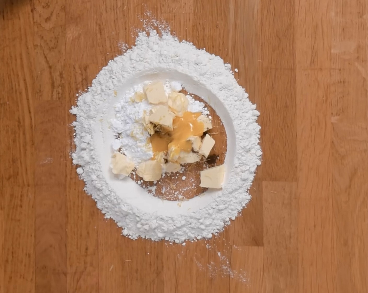 Schritt 2 Mehl (120 g) auf die Arbeitsplatte geben und in der Mitte eine Mulde formen. Danach Puderzucker (4 Esslöffel), Butter (75 g), Salz (1 Pr.), Vanillepulver (1/2 TL), Zitronenabrieb (1) und Eigelb (1) in die Mulde geben und alles zusammen zu einem Teig kneten.