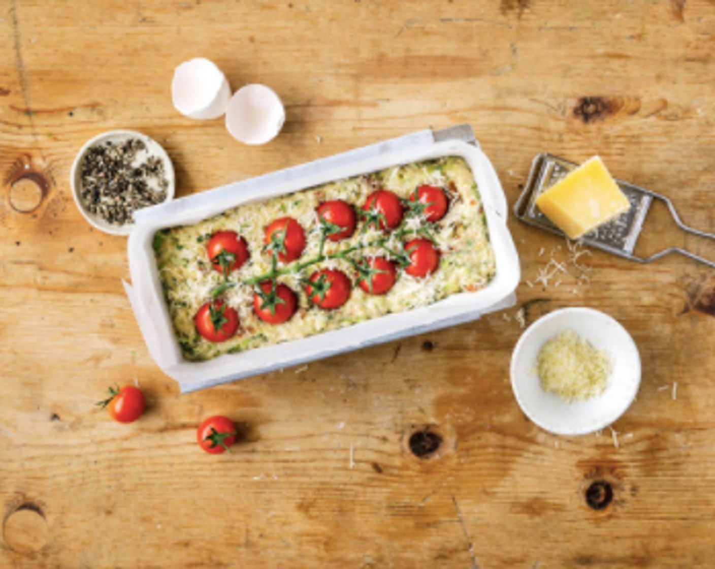 Schritt 4 Den Tomatenzweig (1 Zweig) auf die Oberfläche des Kuchens legen und leicht eindrücken. Mit Käse (2 Esslöffel) bestreuen. Im vorgeheizten Backofen ungefähr 1 Stunde 15 Minuten backen bis die Oberfläche goldgelb ist.