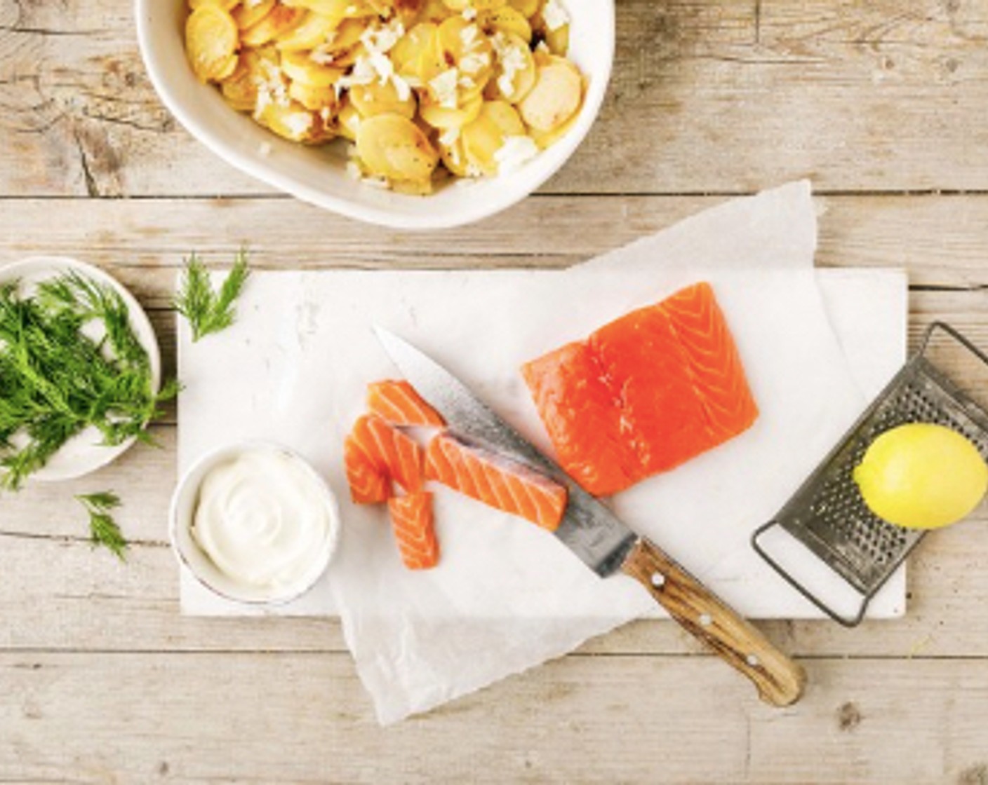 Schritt 3 Den Dill (4 Zweige) grob hacken und mit der Crème Fraîche (100 g) verrühren. Mit den ausgekühlten Kartoffeln und dem Zitronenabrieb (1/2) vermengen. Das Lachsfilet (300 g) in ca. 1 cm breite Stücke schneiden. Den Strudelteig (1 Rolle) sorgfältig auseinander falten, die Teigblätter voneinander lösen, auf ein feuchtes Tuch legen, 1 Teigblatt nach dem anderen mit flüssiger Butter bestreichen, alle Teigblätter aufeinander legen.