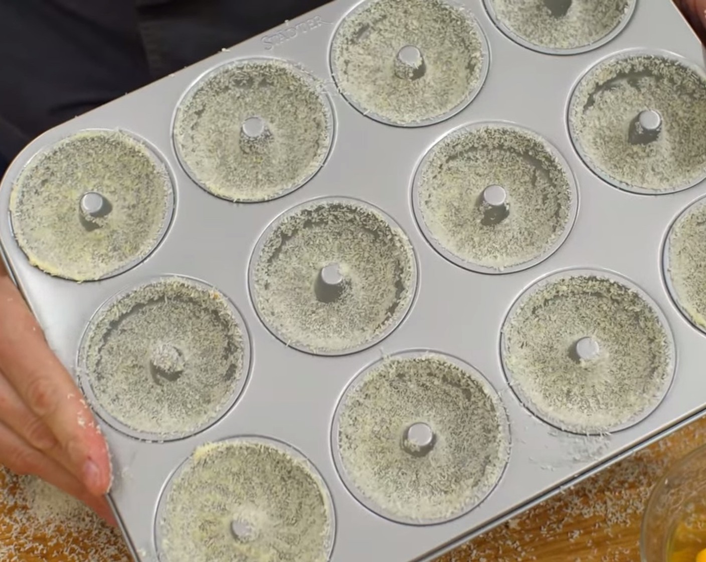 Schritt 3 Die Mulden eines Gugelhupf-Backbleches mit Butter (nach Bedarf) ausfetten und mit Kokosmehl (4 Esslöffel) ausstreuen.