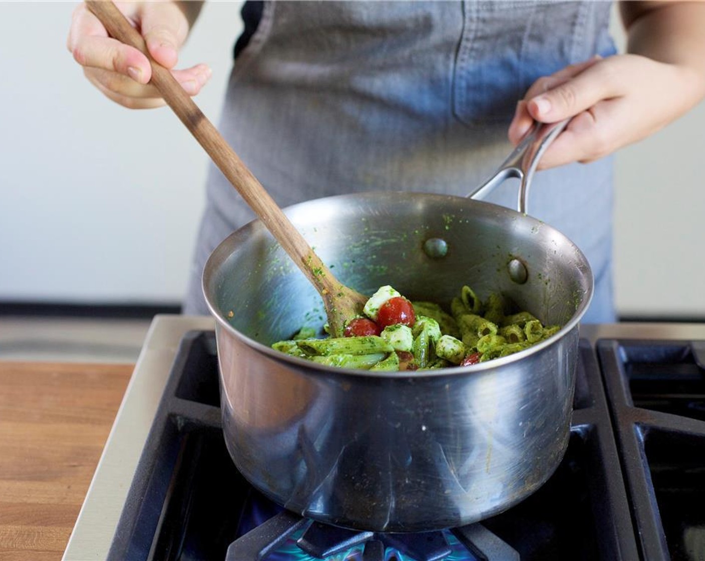Schritt 7 Die Kirschtomaten und den Mozzarella (115 g) hinzufügen. Vorsichtig schwenken, bis der Käse gut bedeckt und warm ist, aber nicht zu sehr schmilzt. Topf vom Herd nehmen.