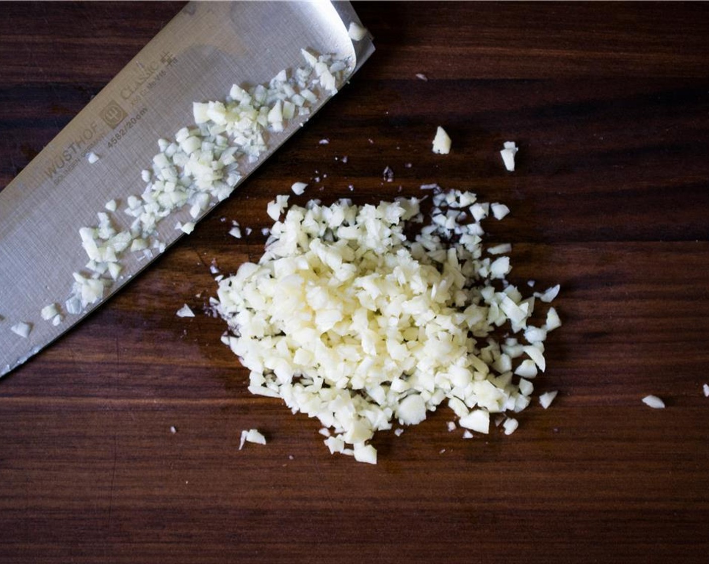 Schritt 2 Knoblauch (4 Zehen) fein hacken. In einer mittelgrossen Pfanne bei mittlerer Hitze das Öl erhitzen und den Knoblauch für etwa 30 Sekunden anbraten, bis das Aroma aufsteigt.