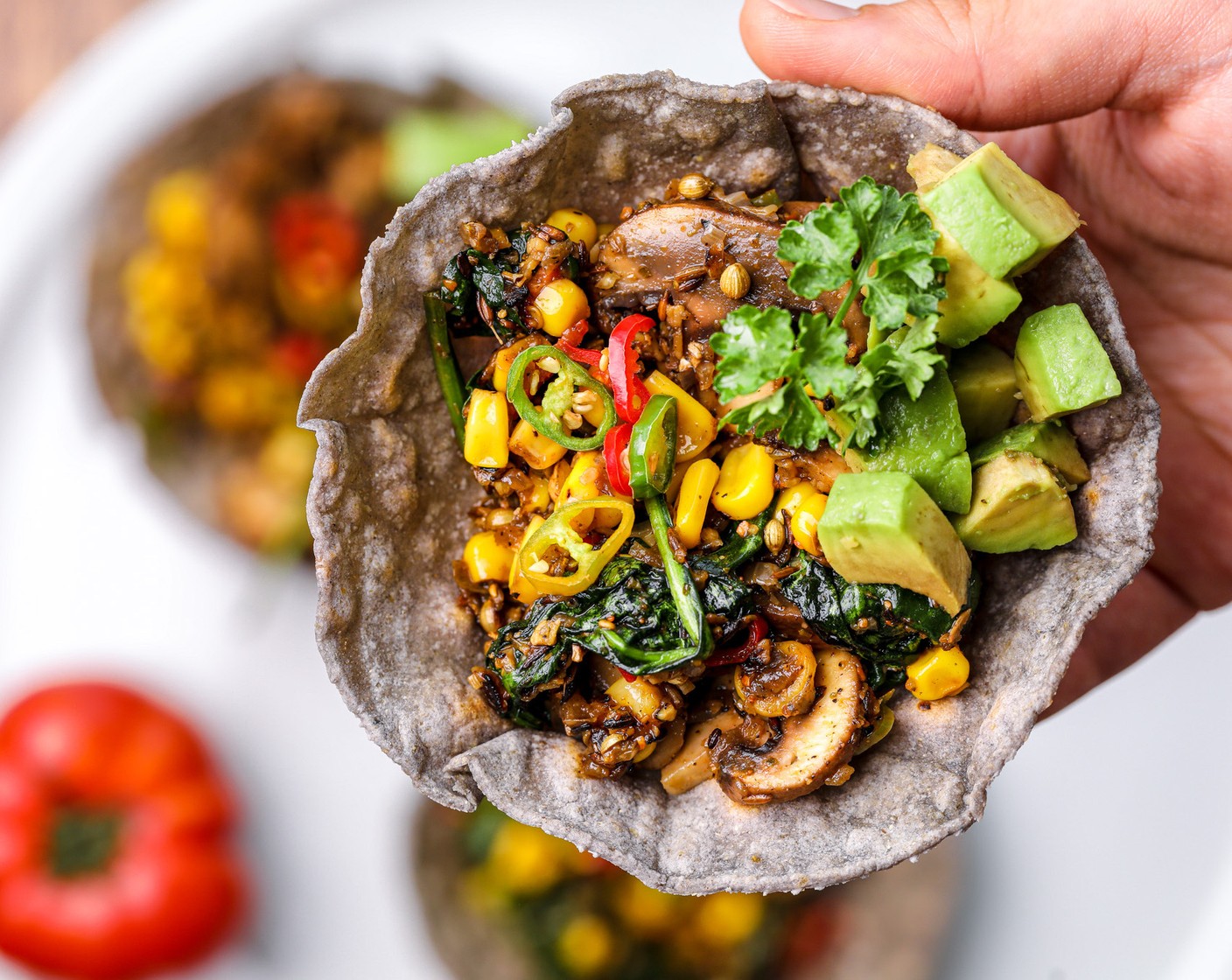 Schritt 7 Verteile die Füllung auf den vorbereiteten Tortilla-Schiffchen. Garniere sie mit Avocadowürfeln (1), Petersilie (wenig) und Chiliringen (1).